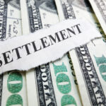 cash and a paper labelled settlement for personal injury settlements